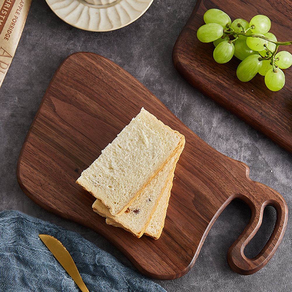 Close-up of black walnut breakfast board with smooth rounded edge and hanging handle